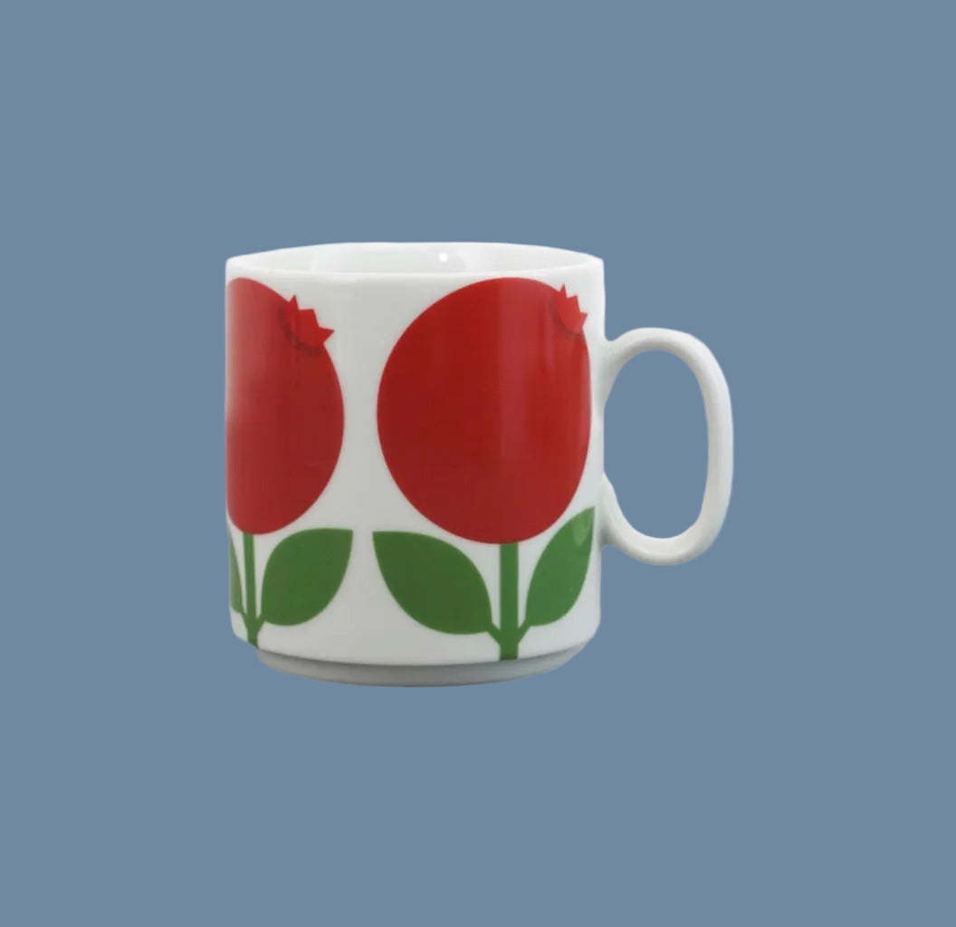 Tasse aus weißem Porzellan mit roten Preiselbeeren