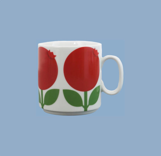 Tasse aus weißem Porzellan mit roten Preiselbeeren
