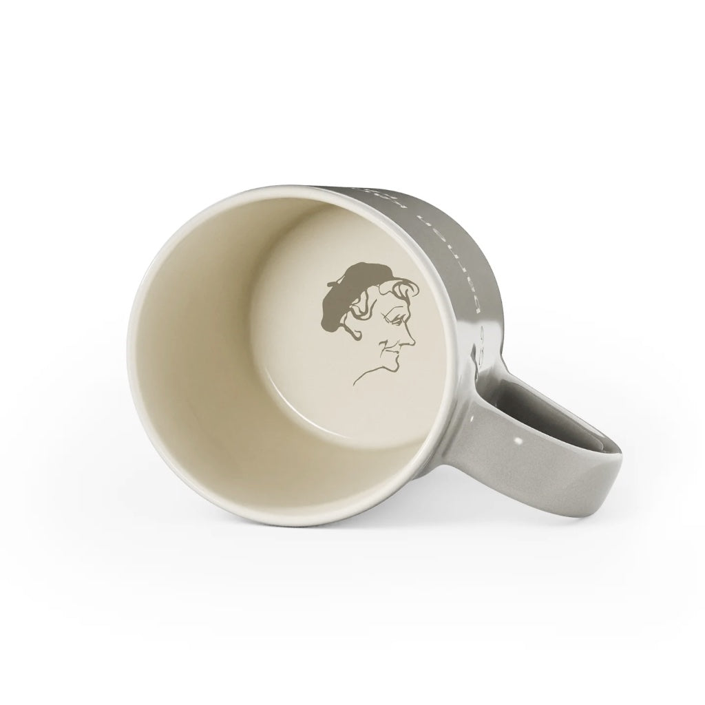 Graue Tasse aus Steingut mit Zitat von Astrid Lindgren liegend mit Konterfei von Astrid Lindgren auf Innenboden