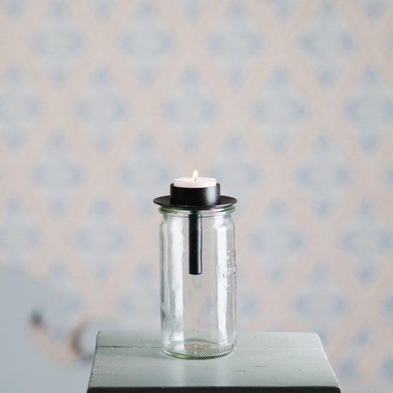 Kerzenhalter für Teelichter aus schwarzem Metall von Våges auf einem geraden Glas
