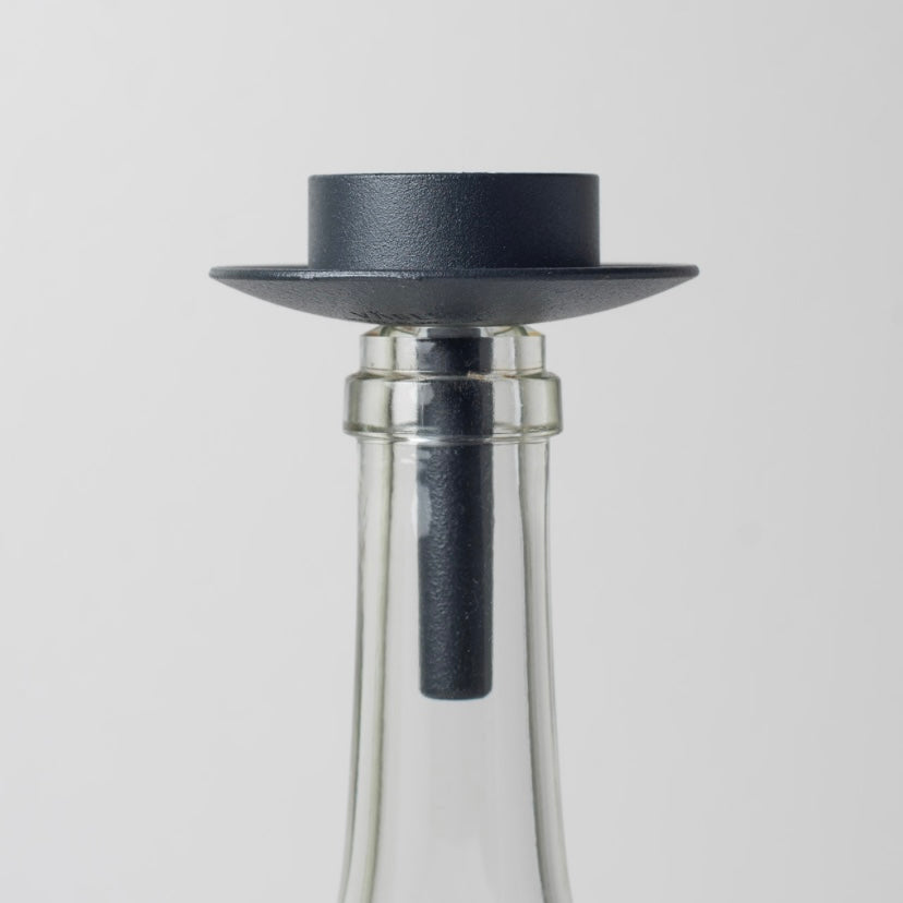 Teelichthalter aus Metall dunkelblau auf weißer Glasflasche