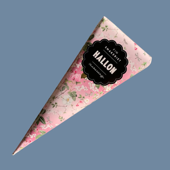 Spitztütchen mit Trüffelpralinen Himbeere vor mysblauem Hintergrund