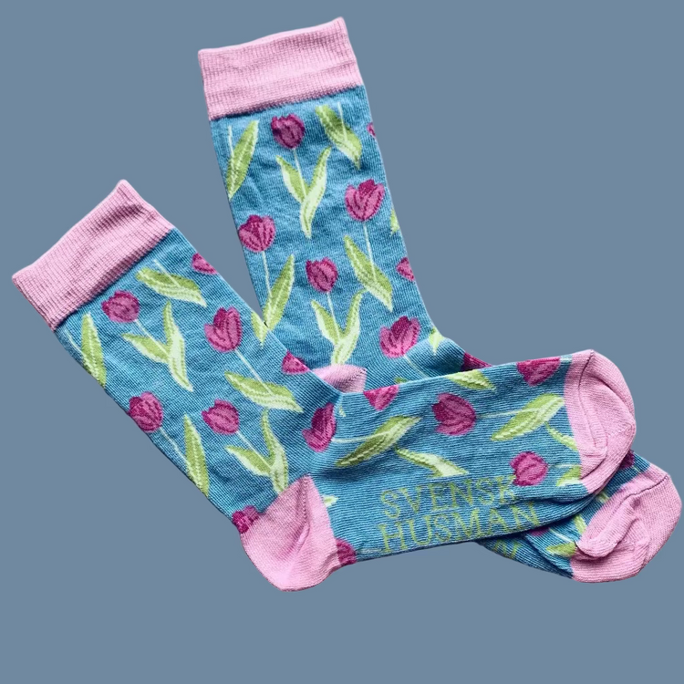 Hellblaue Socken mit lila Tulpen und rosa Ferse und Spitze
