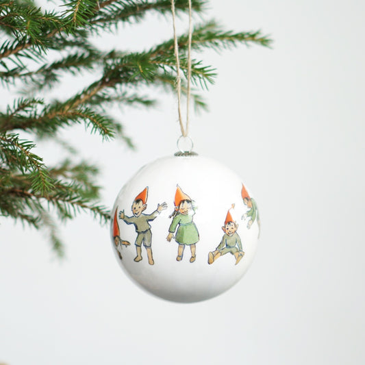 Weihnachtskugel mit Motiv Wichtelschar an grünem Zweig hängend