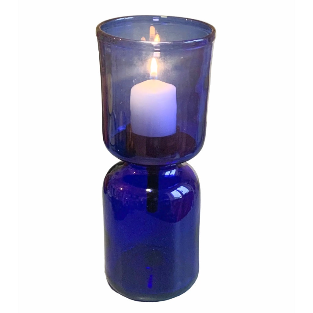 Blaues Windlicht aus Glas vor weißem Hintergrund