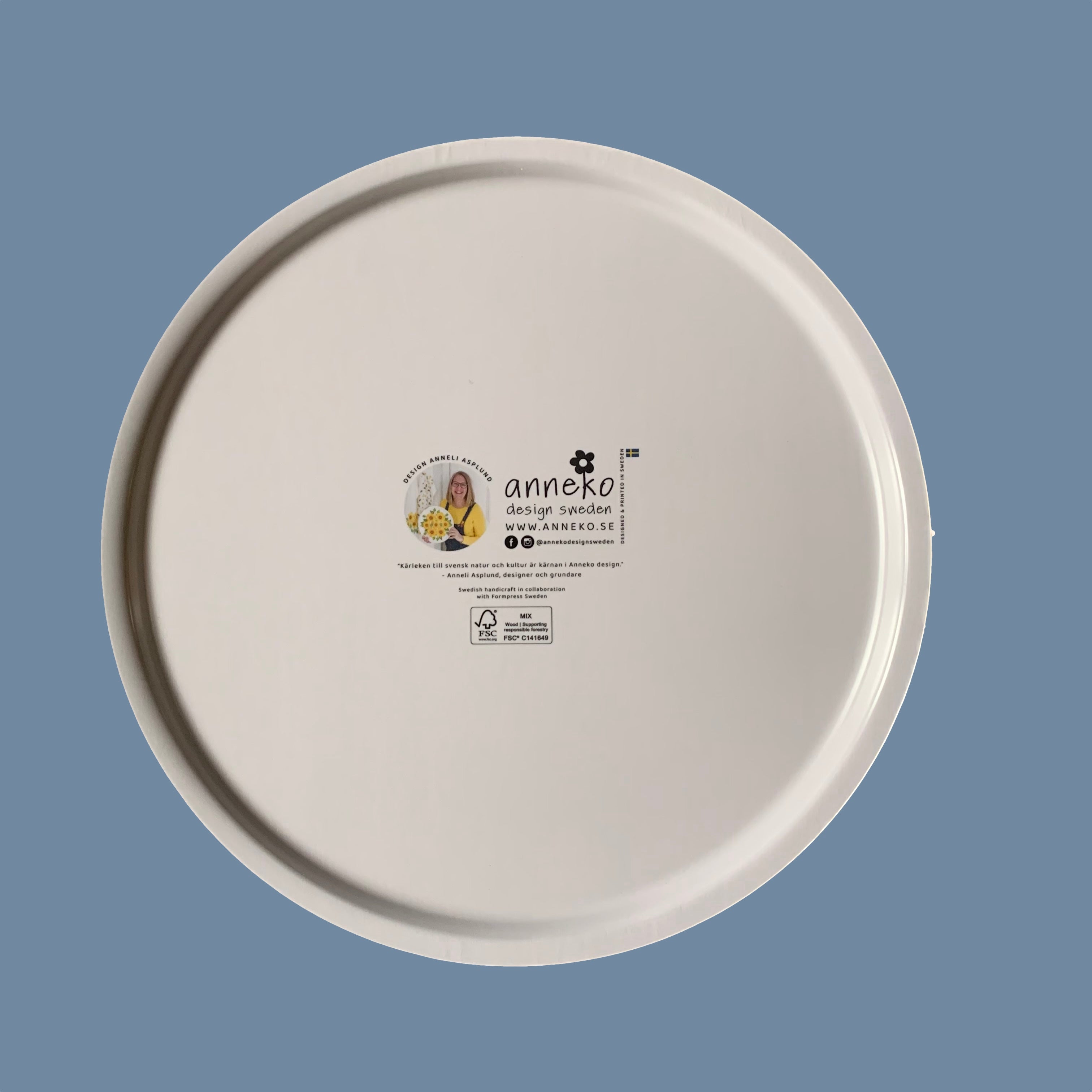 Rücksseite des Runden Holztabletts mit Zitronen mit Info über Anneko Design auf Schwedisch und Englisch