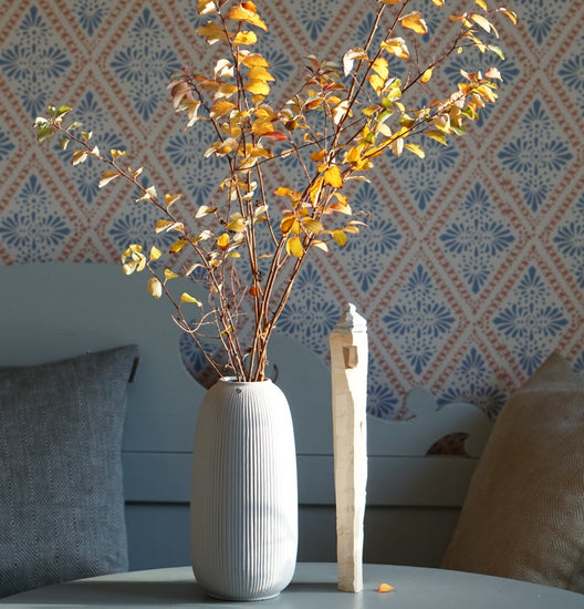 grsue Vase Åby in Grau mit Herbstlaub auf Tisch vor schwedischer Küchenbsnk