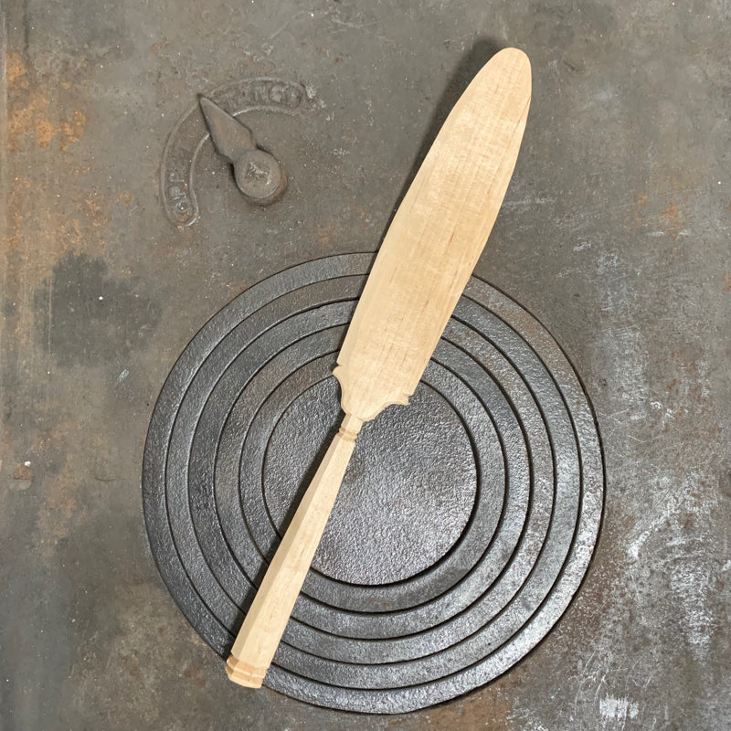 Handwerk aus Schweden, Tortenheber aus Holz auf Küchenofen liegend