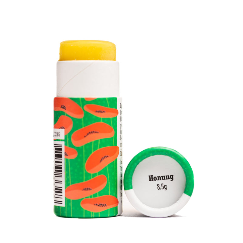 offene, grüne Verpackung mit aufgedruckten Mohnblüten des Lippenbalsams Honig von Gusatf und Linnea