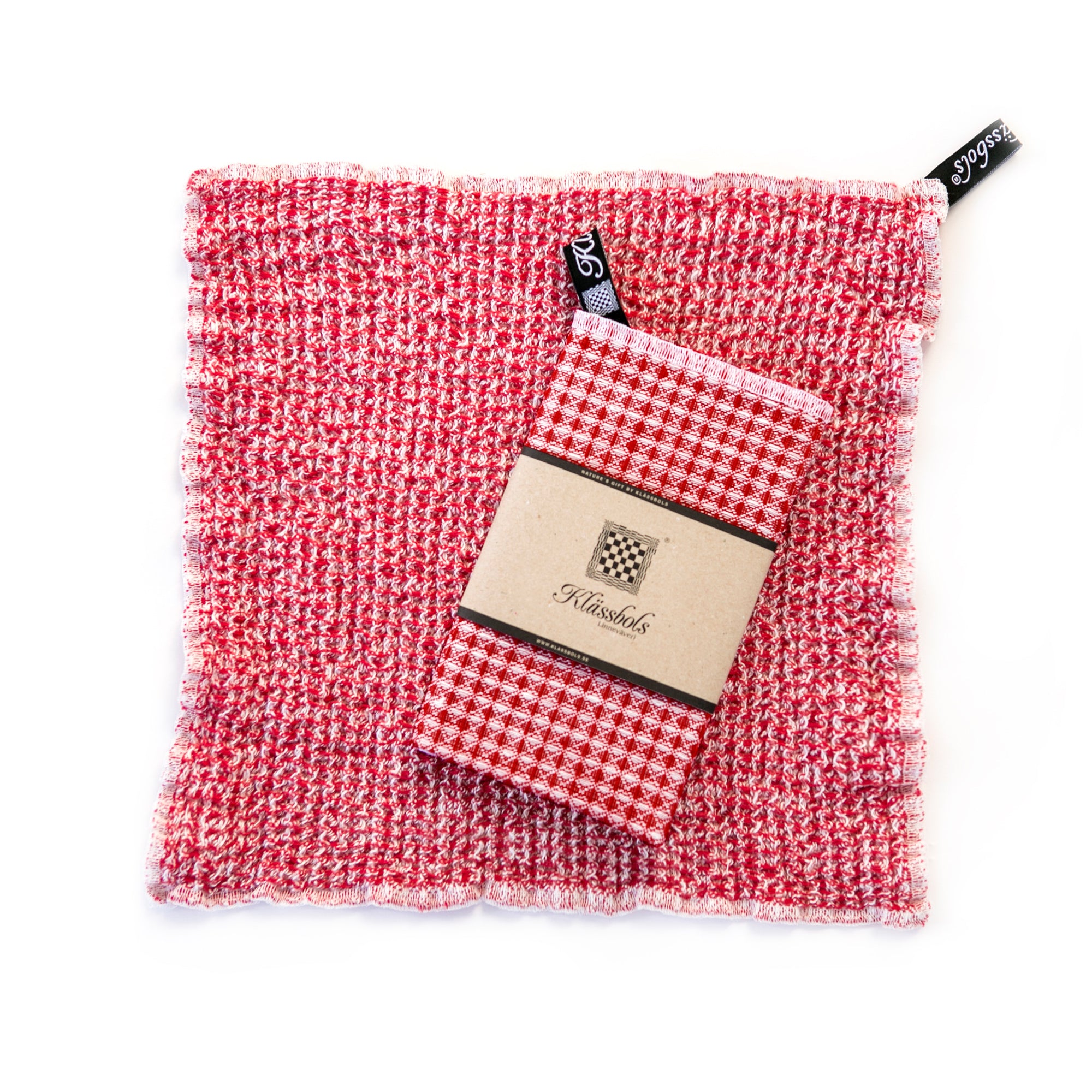 ein gewaschenes Spültuch Bubbel rot Leinen Klässbols linneväveri Mys Shop mit einem neuen Spültuch mit Banderole obenauf liegend