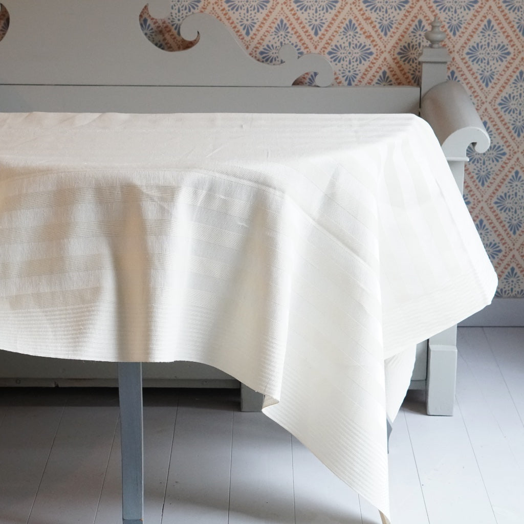 Tischdecke Gästabudaus Leinen weiß auf Tisch vor schwedischem Küchensofa