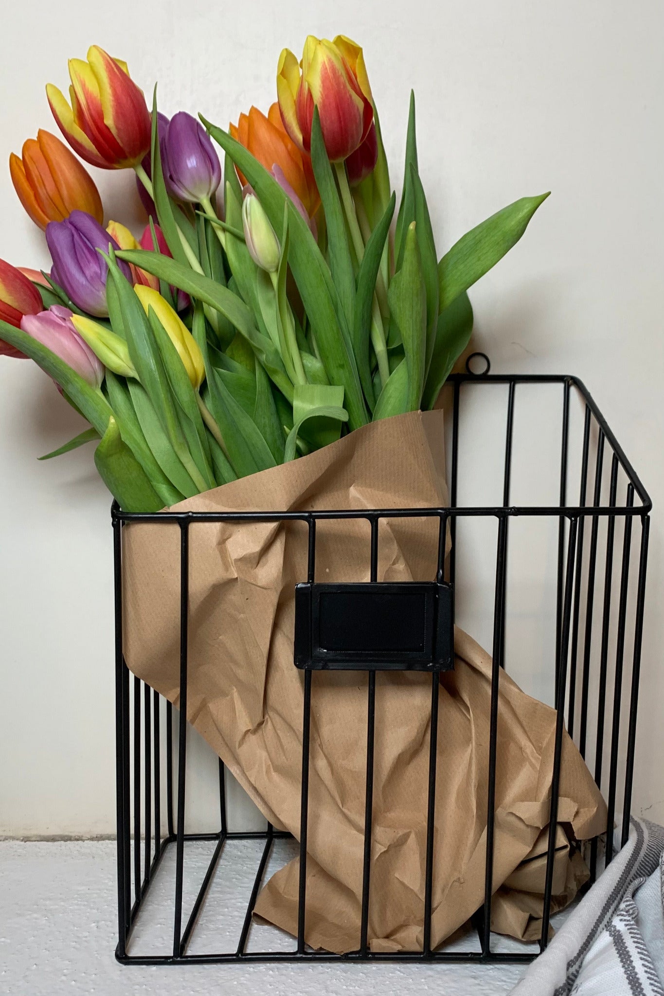 Zeitschriftenhalter mit Tulpenstrauß in Packpapier